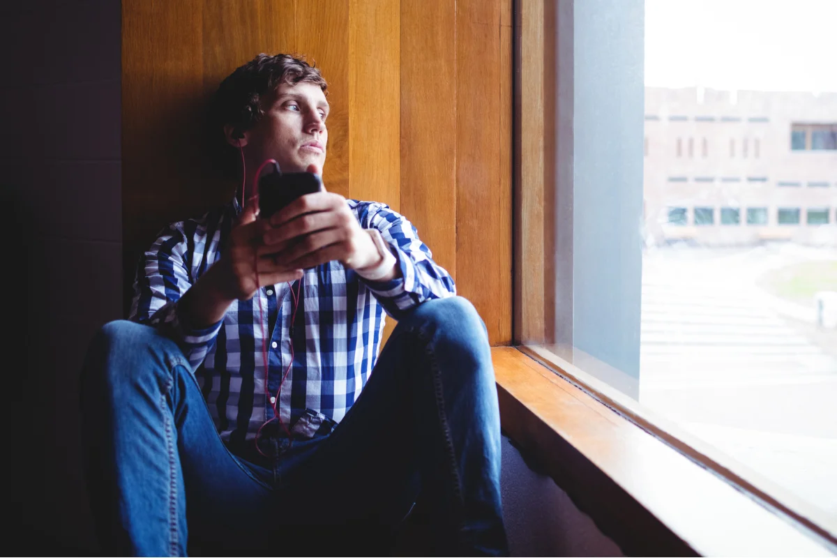 Young man looking out window